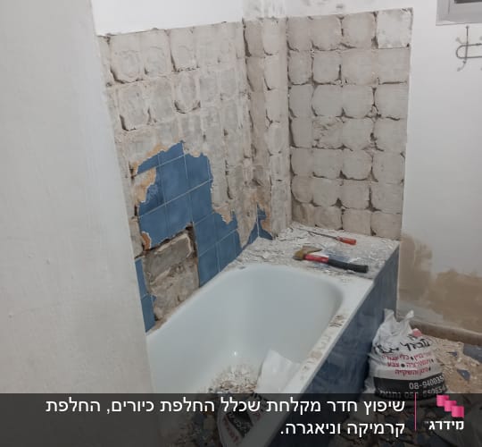 חדר אמבטיה בשיפוץ עם אריחים שבורים וכלי עבודה